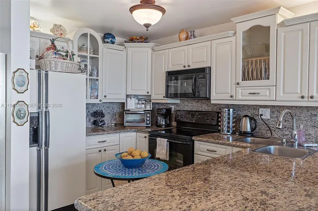 a kitchen with stainless steel appliances granite countertop a sink a stove and cabinets