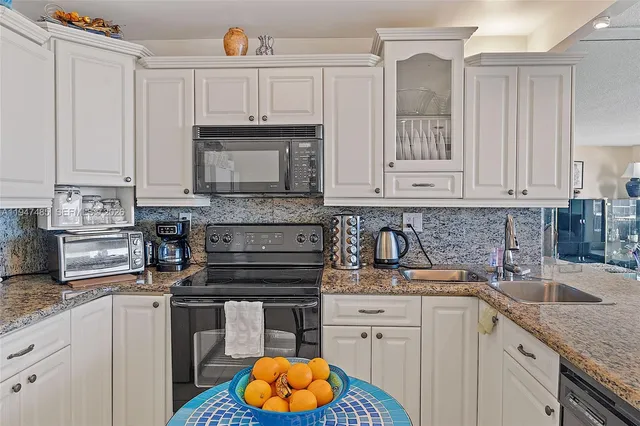 a kitchen with stainless steel appliances granite countertop a refrigerator sink and stove