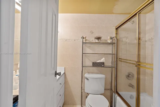 a room with lots of white furniture and chandelier