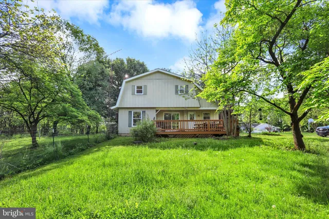 a view of a house with a big yard and large trees