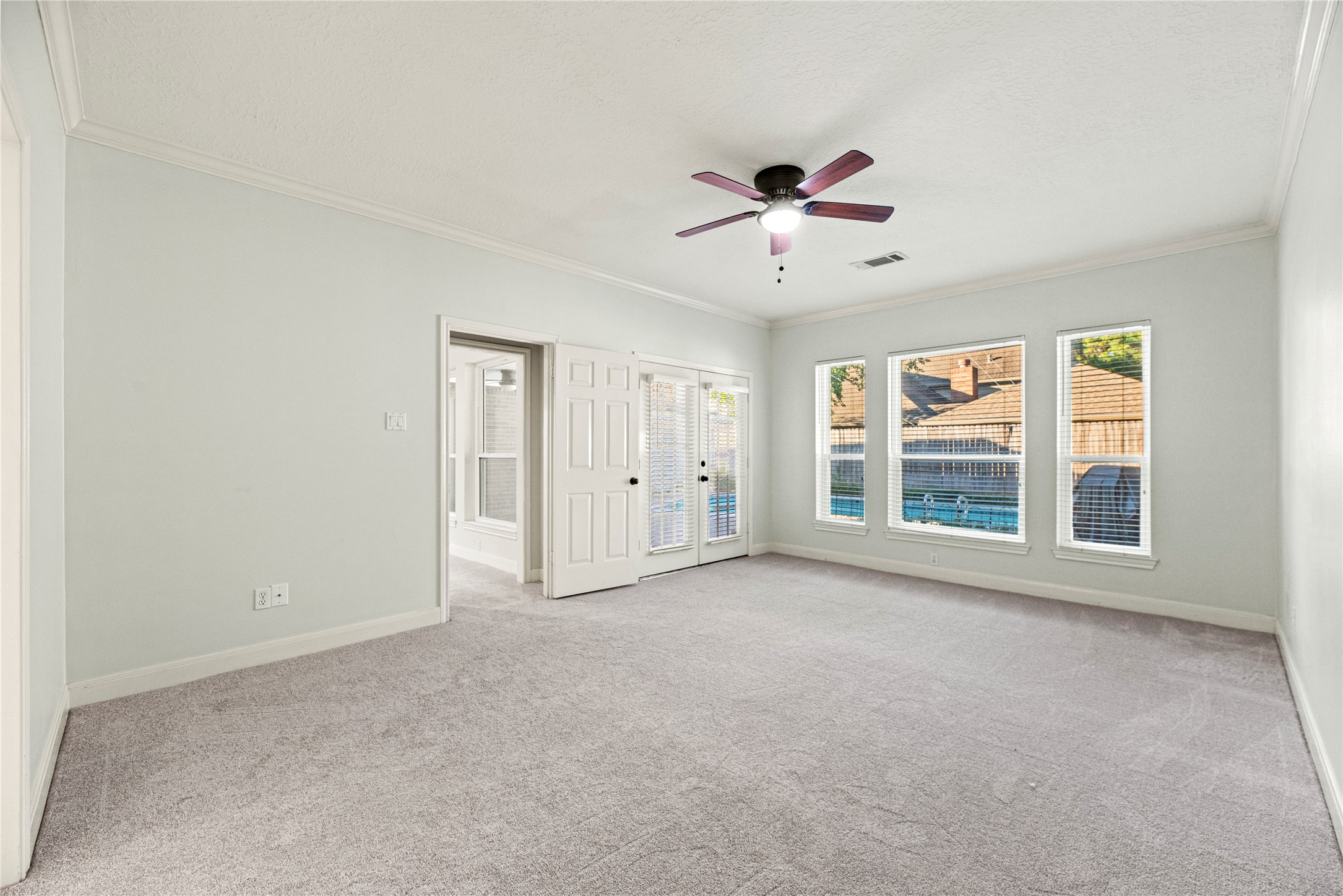 12502 Pavilion Court Tomball, TX 77377 - Photo 20 of 37 The primary retreat features new carpet, crown molding, ceiling fan, en-suite bathroom and direct access to the backyard.