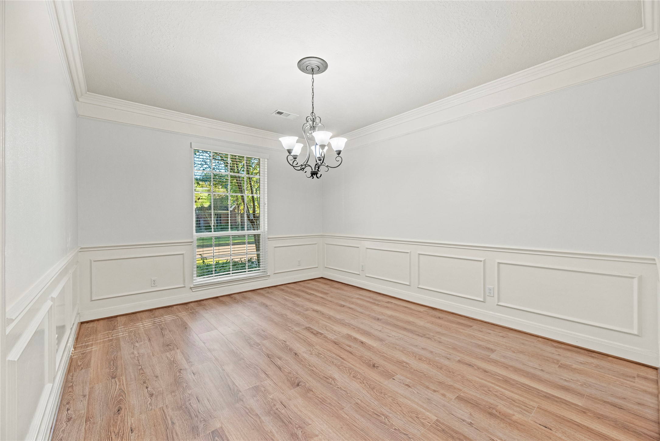12502 Pavilion Court Tomball, TX 77377 - Photo 9 of 37 Formal dining room with crown molding, chair rail with picture frame wainscot and an elegant light fixture.