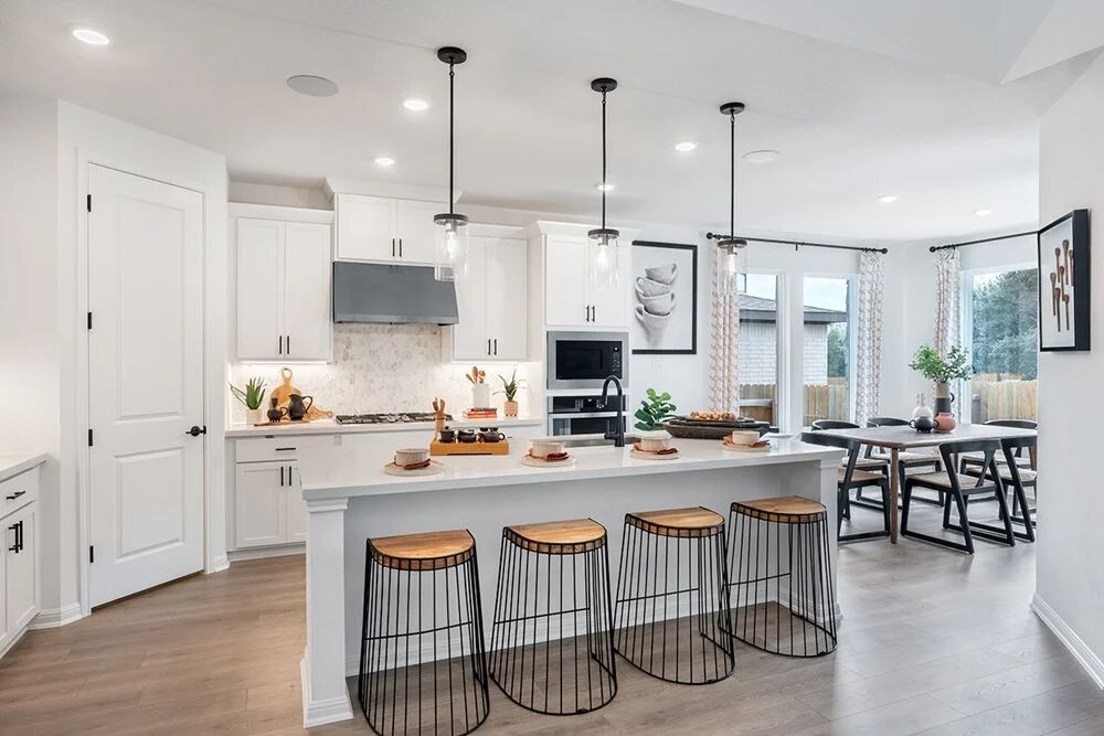 1912 Montella Way Leander, TX 78641 - Photo 10 of 31 a kitchen with kitchen island granite countertop a dining table chairs and white cabinets
