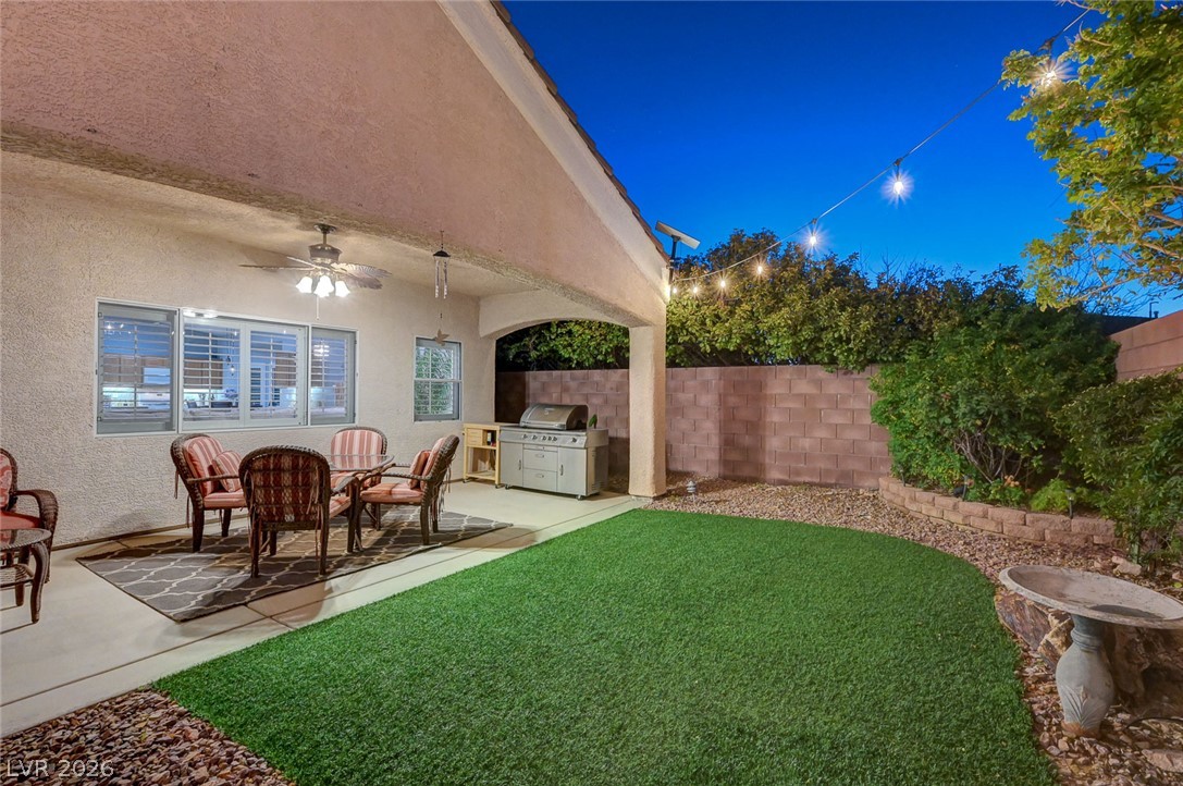 1604 Cattle Ranch Place Henderson, NV 89002 - Photo 93 of 99 A private backyard oasis with covered patio dining and low-maintenance artificial turf.