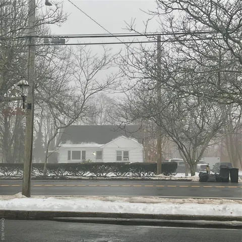 a view of a house with a yard and road