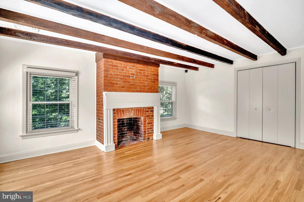 513 Cherry Valley Road Princeton, NJ 08540 - Photo 46 of 52 an empty room with wooden floor fireplace and windows