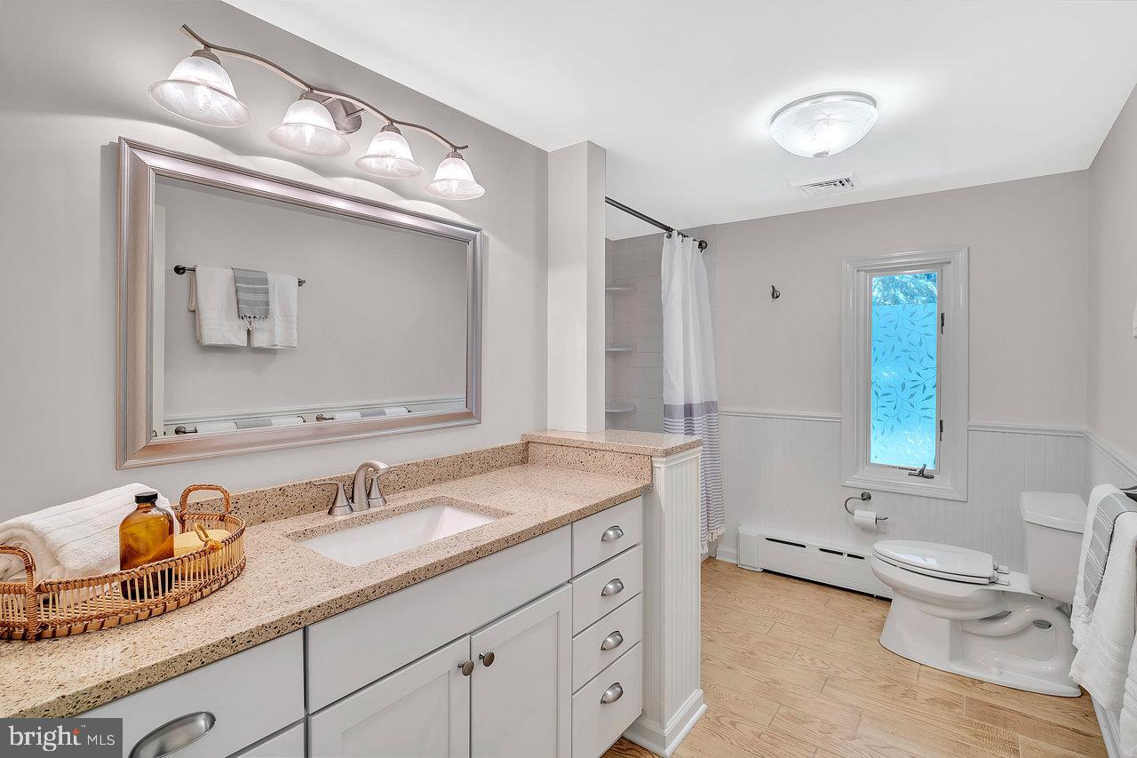 513 Cherry Valley Road Princeton, NJ 08540 - Photo 47 of 52 a bathroom with a granite countertop toilet a double vanity sink a mirror and a window