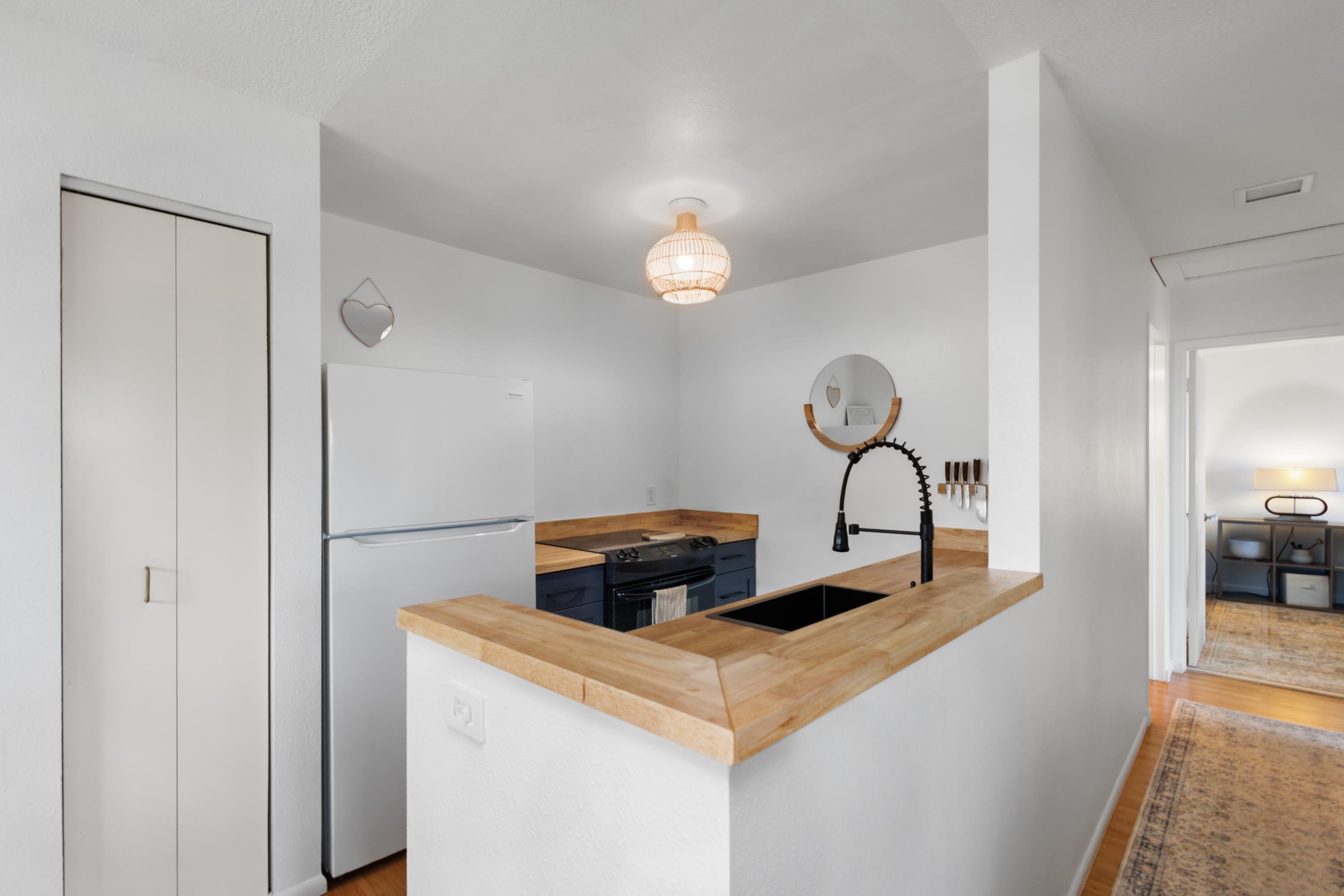 160 Keonekai Road, Unit 22201 Kihei, HI 96753 - Photo 5 of 37 a kitchen with a refrigerator and cabinets