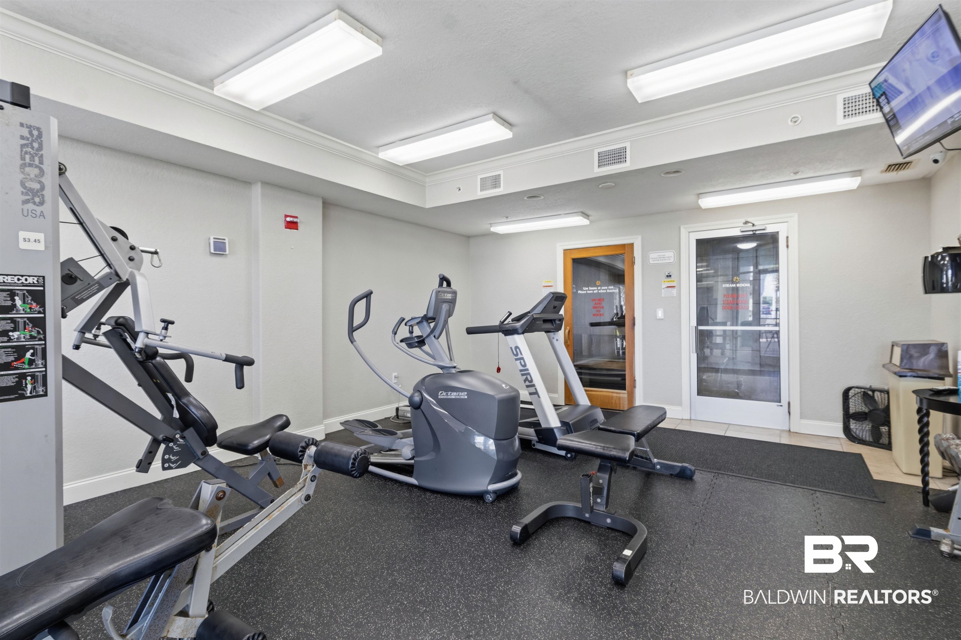 3564 Bayou Road, Unit 203 Orange Beach, AL 36561 - Photo 30 of 53 Fitness room featuring commercial-grade workout equipment, rubberized flooring, flush-mount ceiling lights, crown molding, and a wall-mounted television
