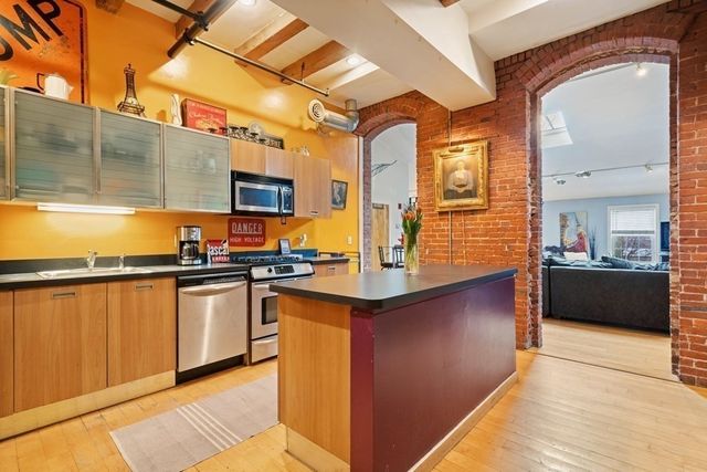 a kitchen with stainless steel appliances granite countertop a sink and a stove