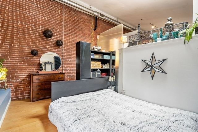 a bedroom with a bed and a view of kitchen