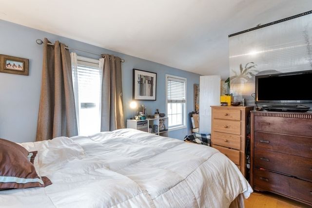 a bedroom with a bed and flat screen tv