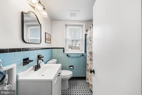 a bathroom with a sink mirror and toilet