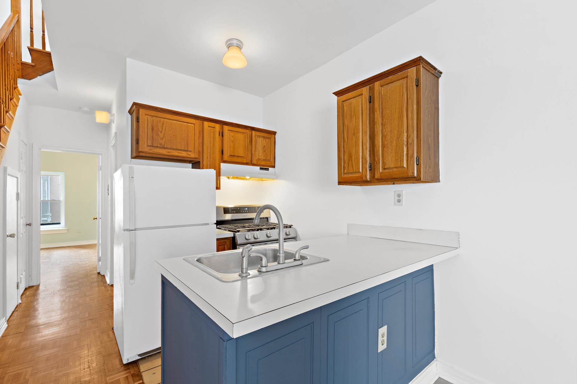 82 Jackson Street, Unit B5 Hoboken, NJ 07030 - Photo 4 of 14 a white kitchen with a sink a refrigerator and a stove