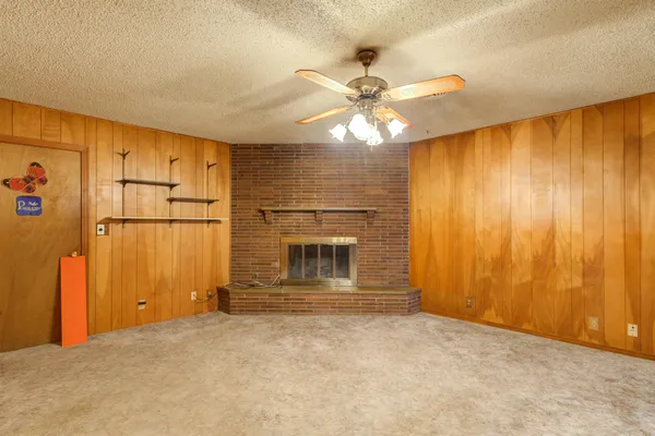 a view of a livingroom with a chandelier fan and fire place