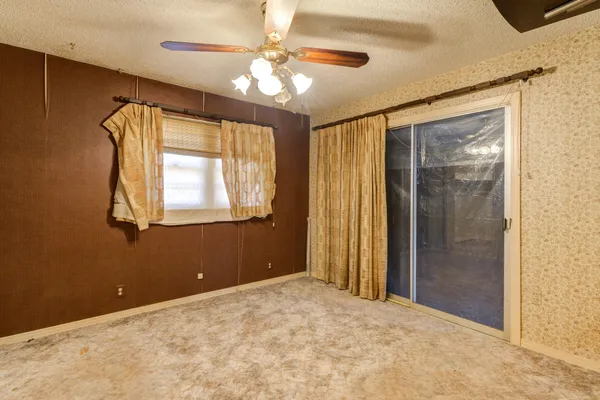 a view of a livingroom with a chandelier fan and a window