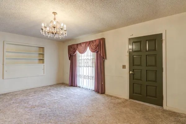 an empty room with windows and cabinet
