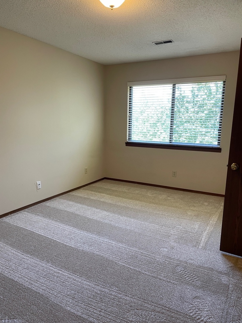 2148 Sunview Drive, Unit 2148 Champaign, IL 61821 - Photo 5 of 8 a view of an empty room with a window