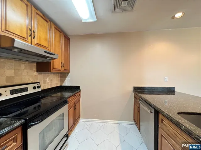 a kitchen with granite countertop a sink and cabinets