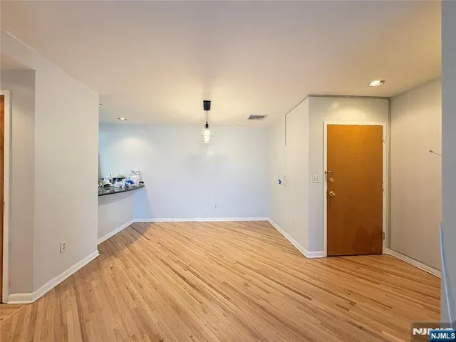 a view of a room with wooden floor and a ceiling fan