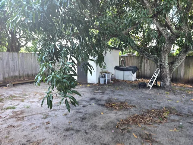 a view of a patio with table and chairs with wooden fence and plants