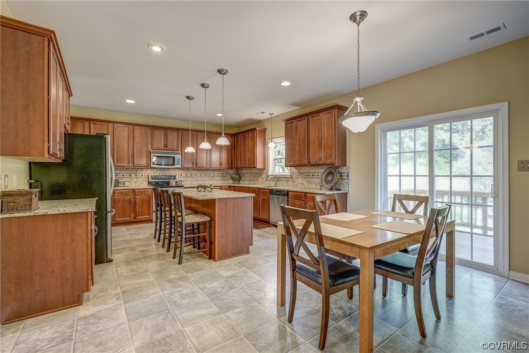 2407 Cascade Meadows Drive Midlothian, VA 23112 - Photo 15 of 48 a kitchen with stainless steel appliances granite countertop a stove a refrigerator a kitchen island a table and chairs