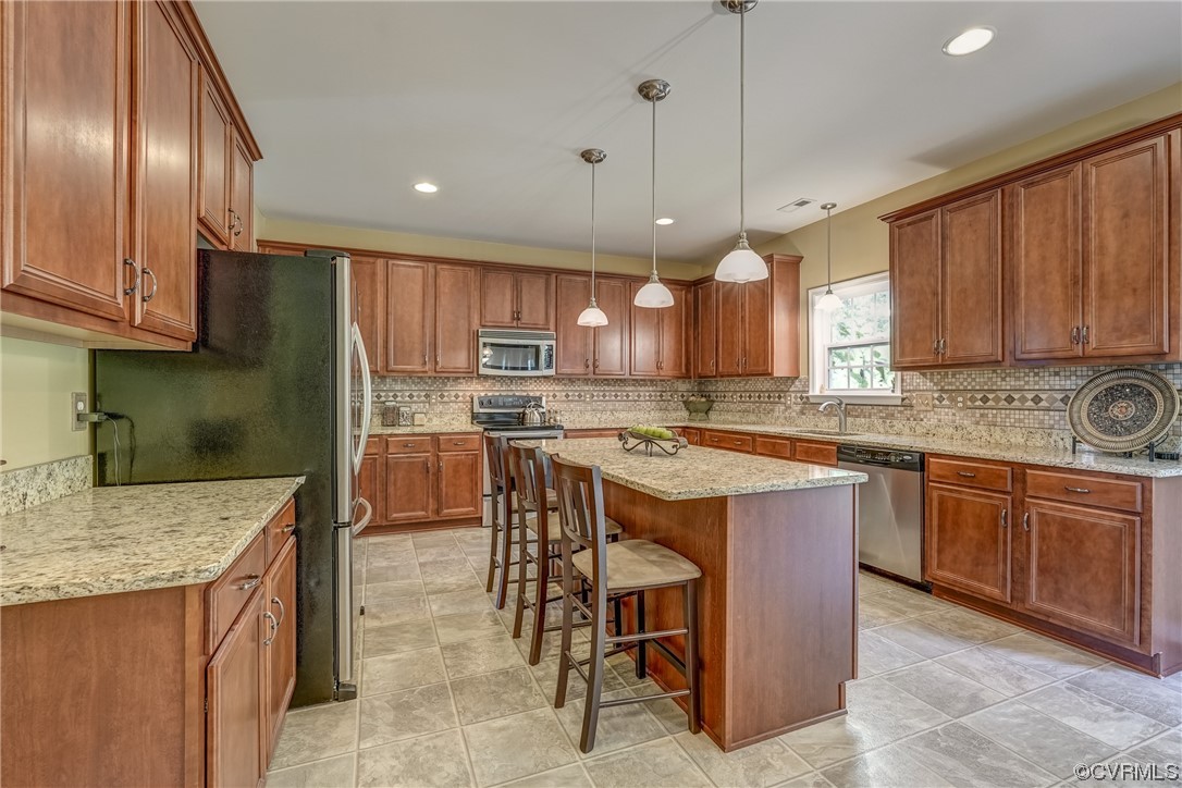 2407 Cascade Meadows Drive Midlothian, VA 23112 - Photo 16 of 48 a kitchen with stainless steel appliances granite countertop wooden cabinets a stove a sink and a refrigerator