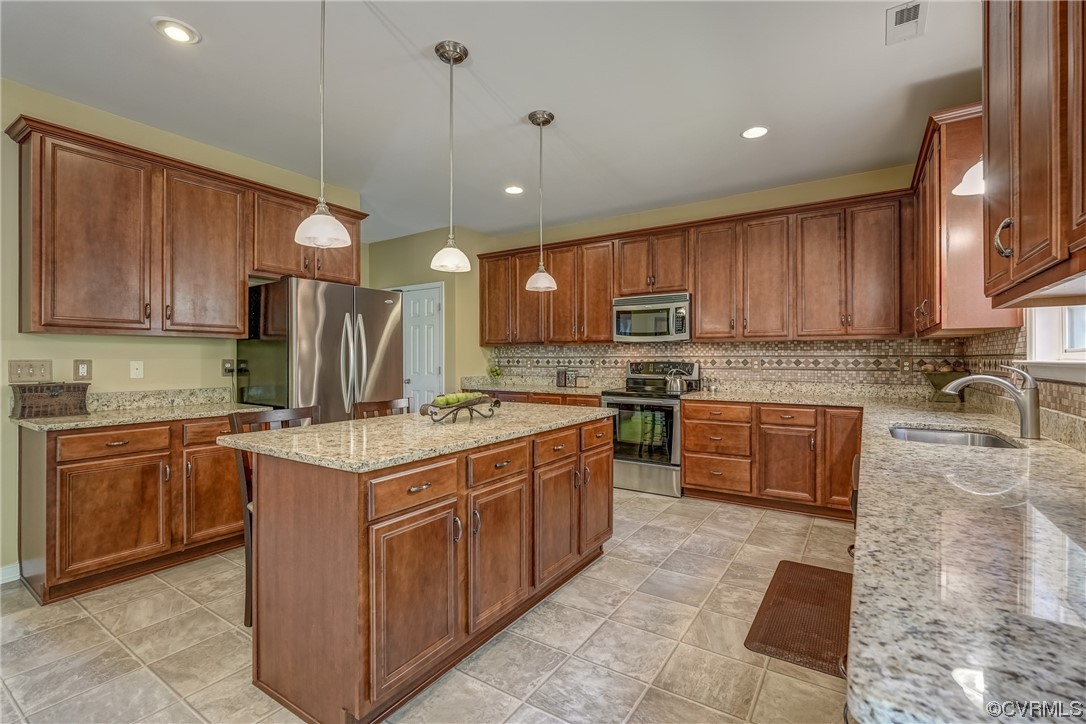 2407 Cascade Meadows Drive Midlothian, VA 23112 - Photo 19 of 48 a kitchen with stainless steel appliances granite countertop wooden cabinets a stove a sink and a refrigerator