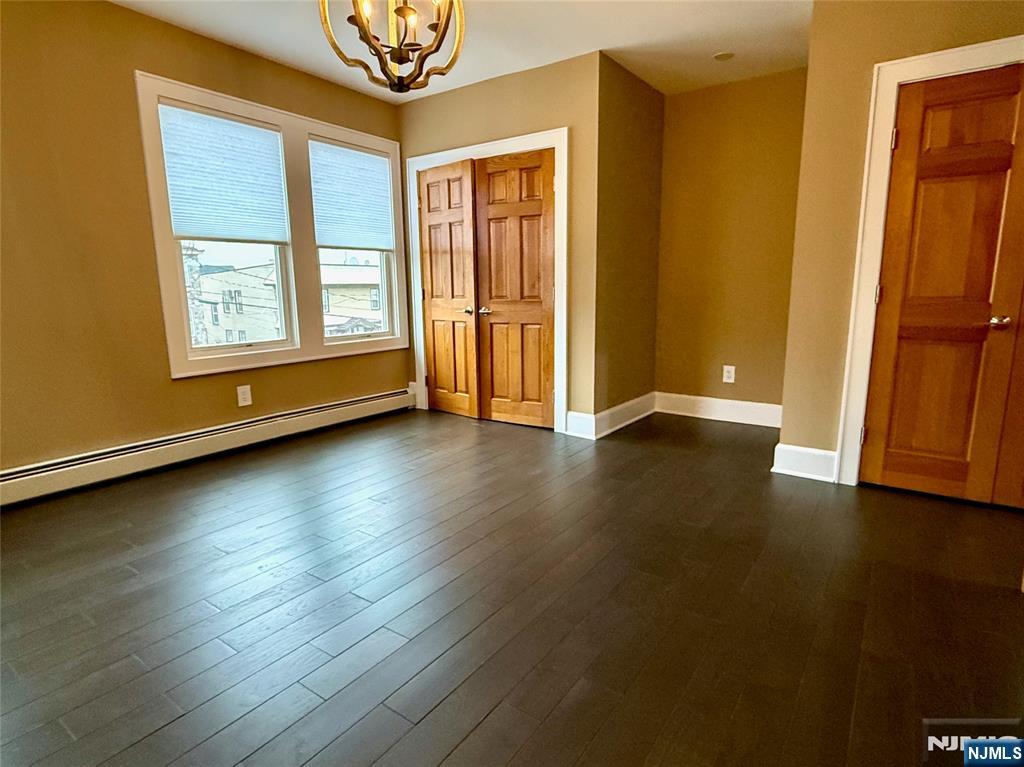 59 Laurel Avenue, Unit RIGHT SIDE Kearny, NJ 07032 - Photo 12 of 16 a view of an empty room with wooden floor and a window