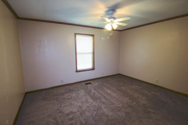 4 Broyles Road Phenix City, AL 36869 - Photo 13 of 15 an empty room with a chandelier fan and windows