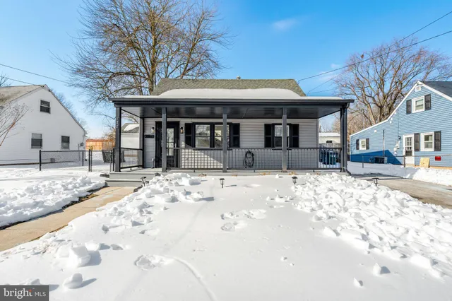 a front view of a house with a yard covered in snow