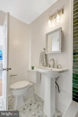 a view of an empty room with window and hardwood floor