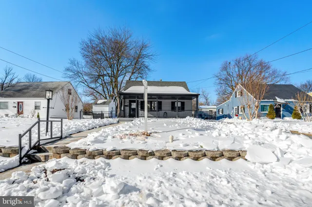 a front view of a house with a yard covered in snow