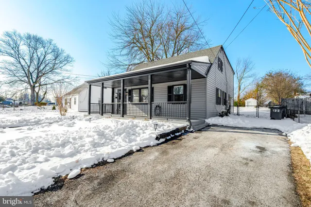 a front view of a house with a yard covered in snow