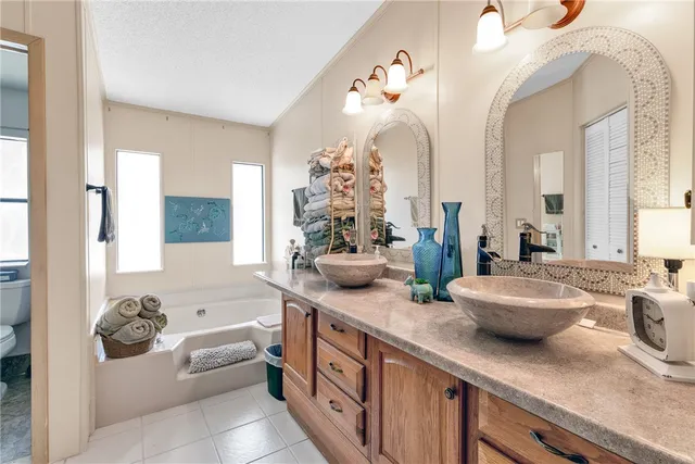 a bathroom with a double vanity sink mirror and bathtub
