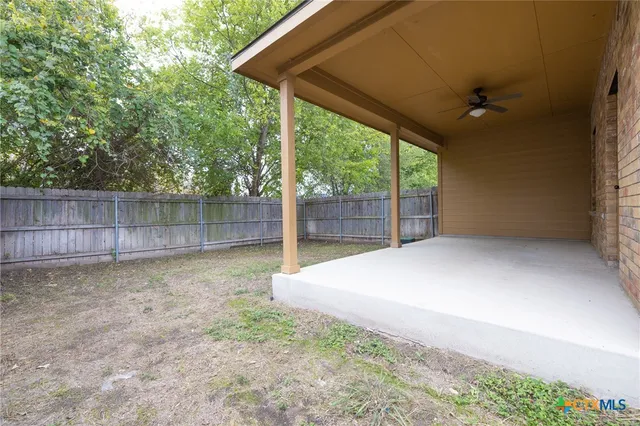 a view of backyard with tree and wooden fence