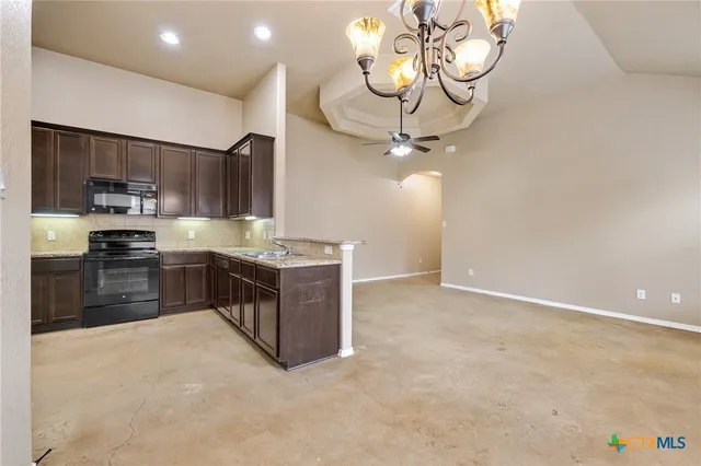 a kitchen with stainless steel appliances a stove top oven a sink dishwasher and a refrigerator with wooden floor