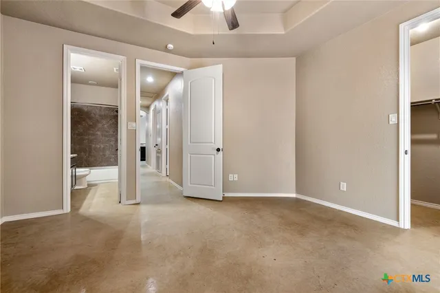 an empty room with closet and a chandelier fan