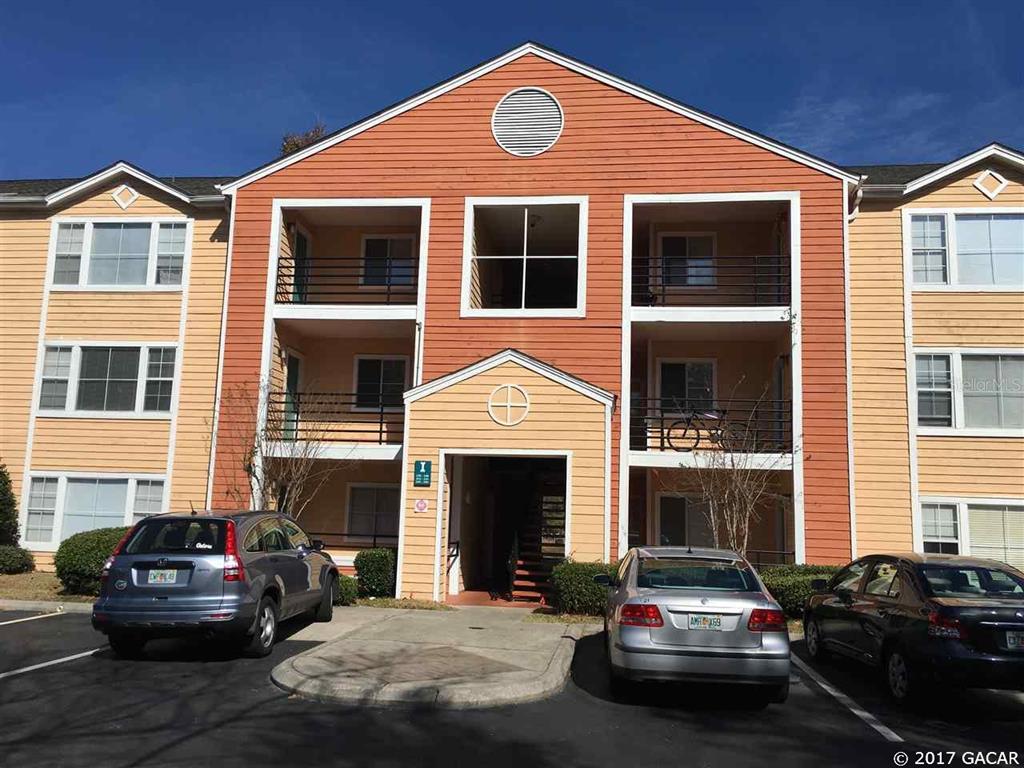 a front view of a house with cars parked
