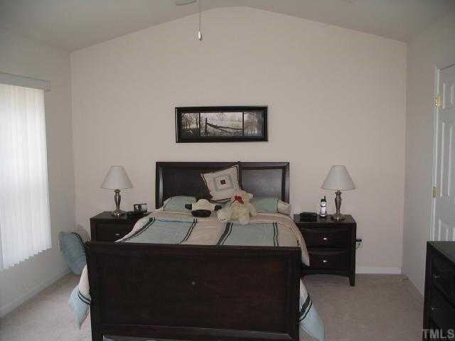 8159 Rhiannon Road Raleigh, NC 27613 - Photo 5 of 12 a bed room with a bed and a lamp