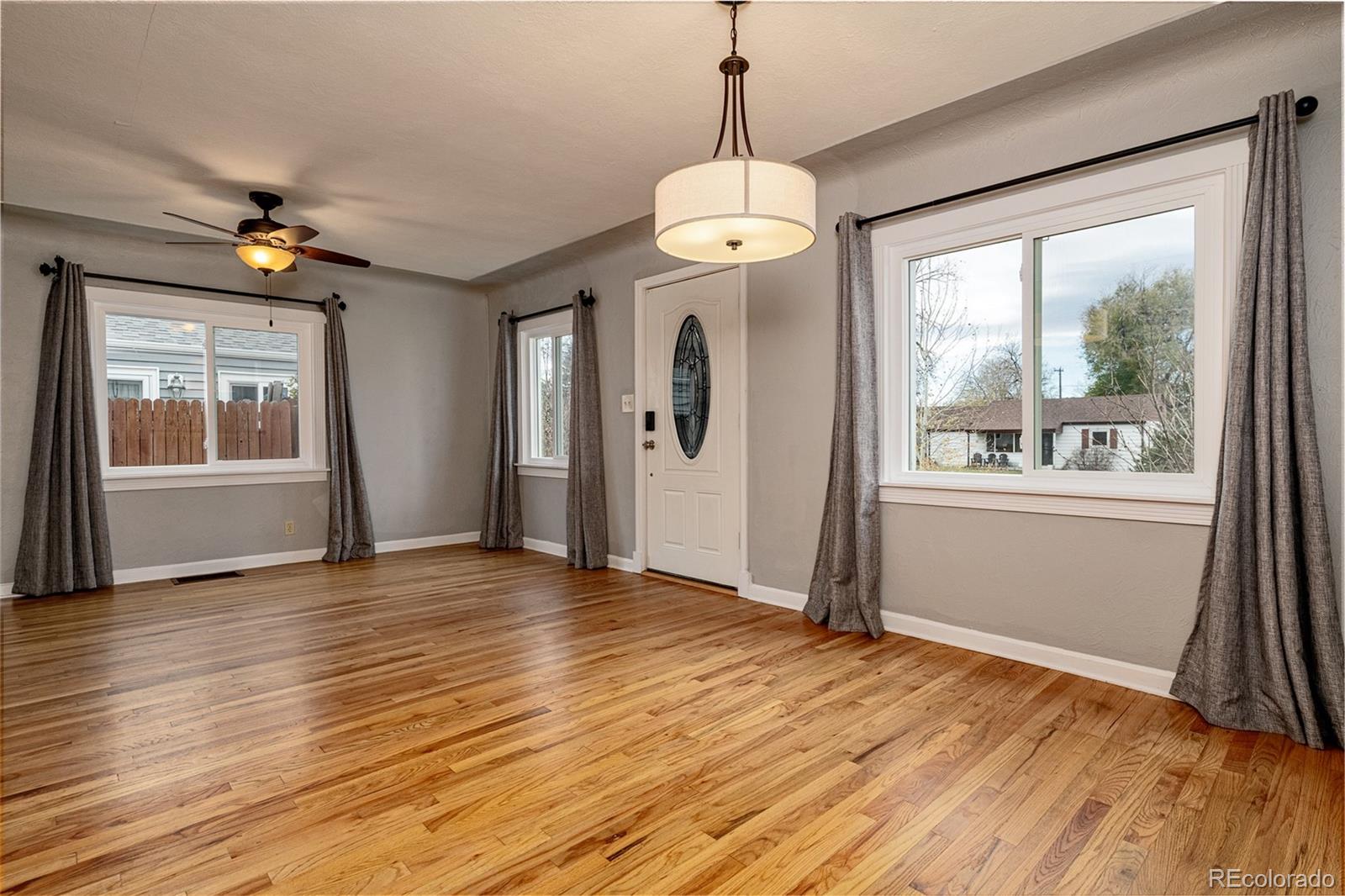 1250 Emporia Street Aurora, CO 80010 - Photo 13 of 33 a view of an empty room with a window and wooden floor