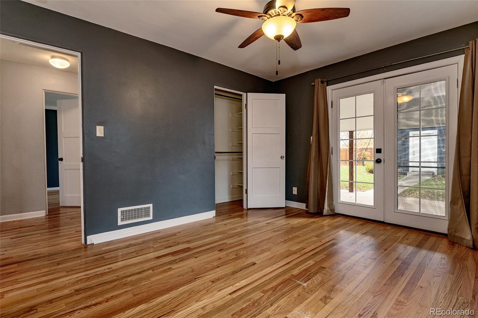 1250 Emporia Street Aurora, CO 80010 - Photo 16 of 33 a view of an empty room with wooden floor and a window
