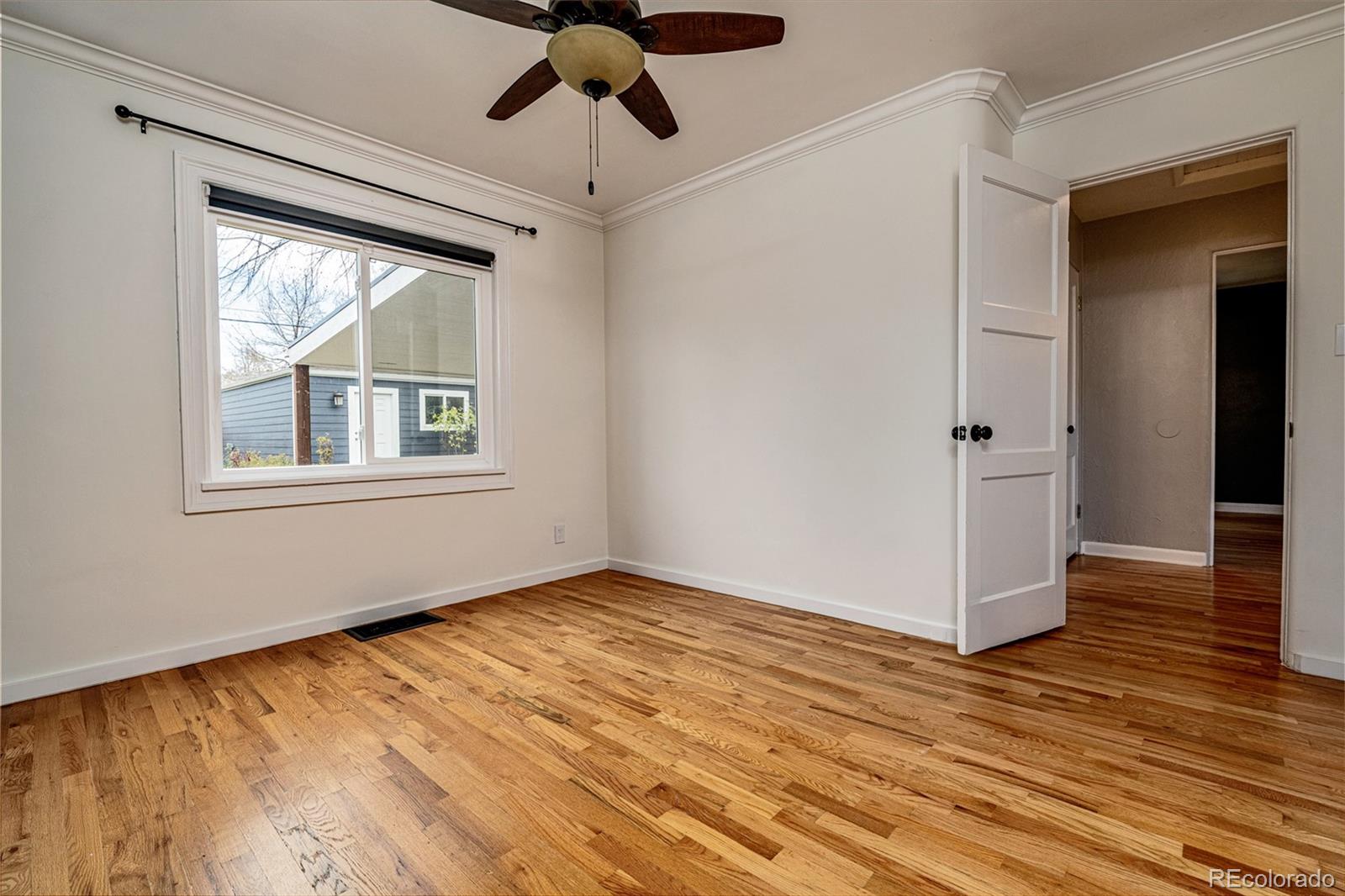 1250 Emporia Street Aurora, CO 80010 - Photo 20 of 33 a view of an empty room with wooden floor and a window