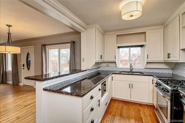 a kitchen with granite countertop a sink a counter space appliances and cabinets
