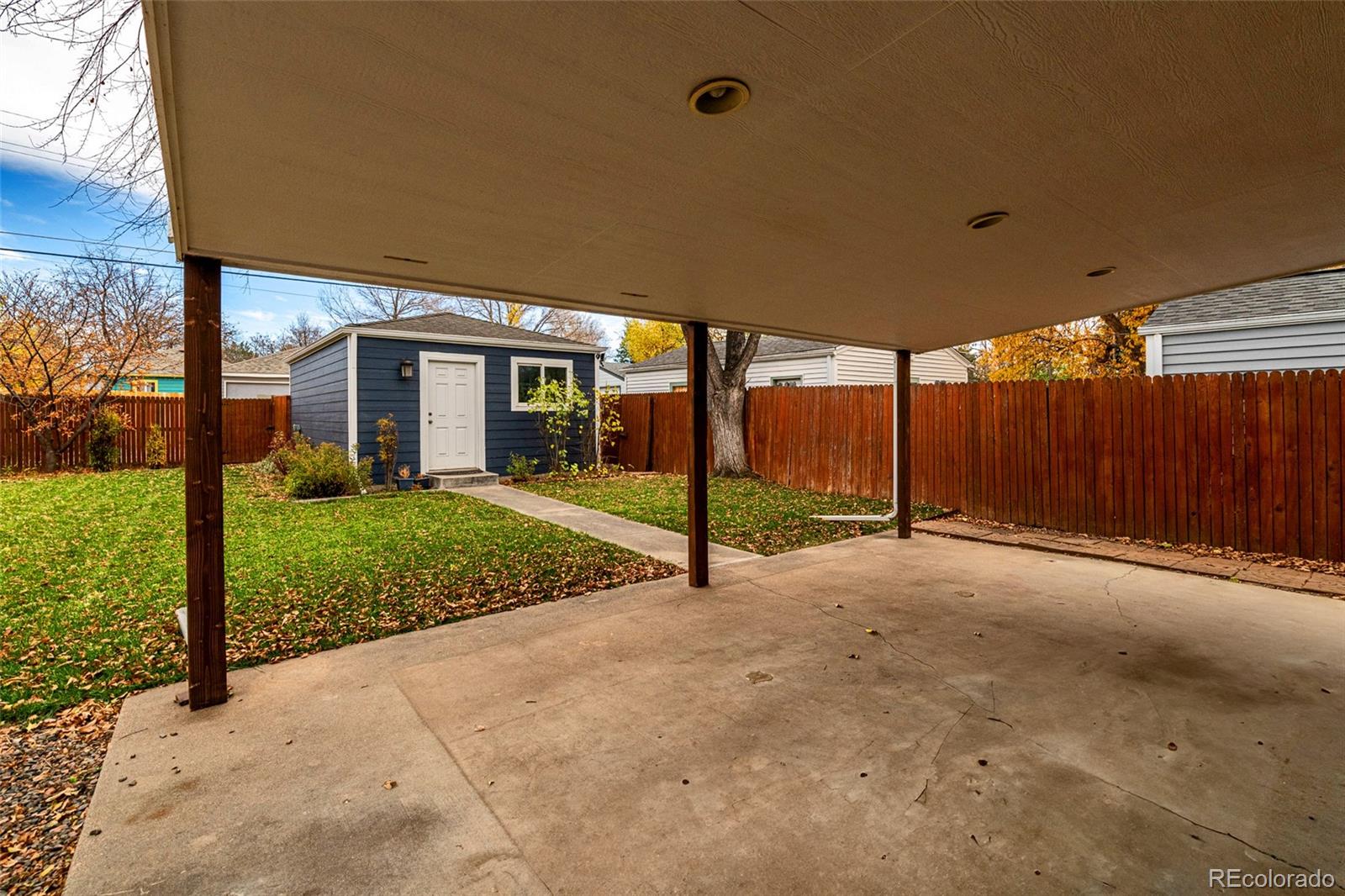 1250 Emporia Street Aurora, CO 80010 - Photo 24 of 33 a view of a house with backyard and floor to ceiling window and wooden fence