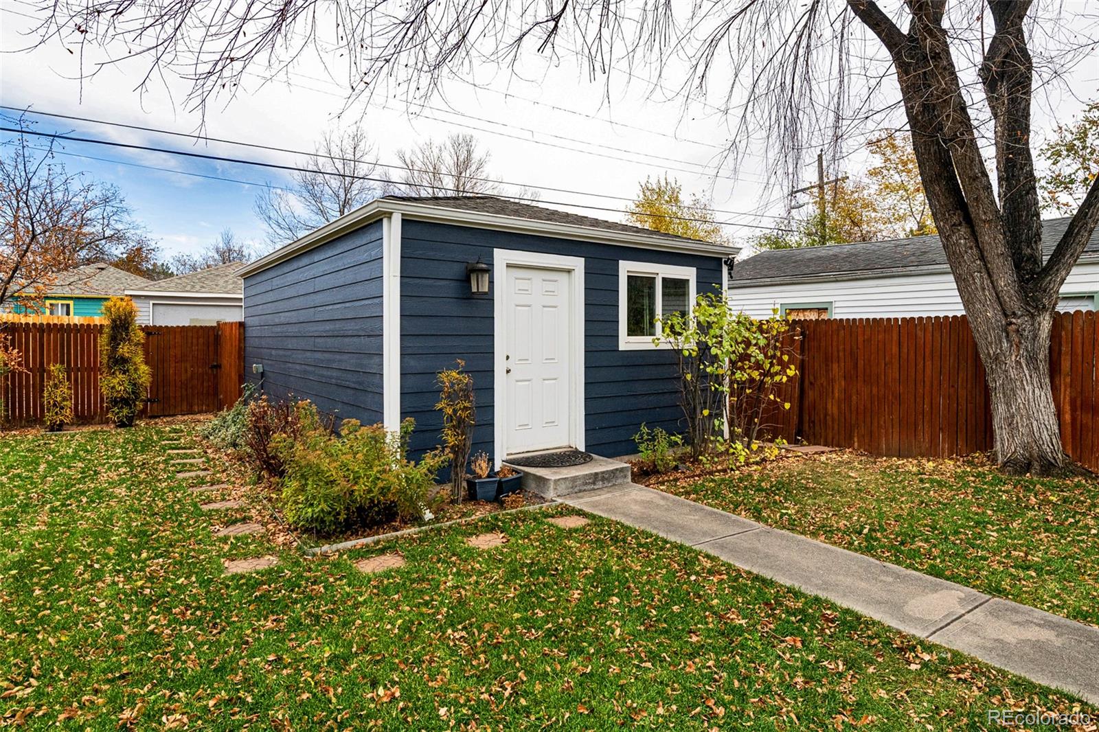1250 Emporia Street Aurora, CO 80010 - Photo 27 of 33 a view of a house with a small yard and a large tree