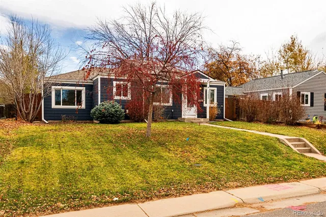 a front view of house with yard and trees around