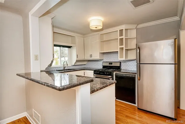 a kitchen with granite countertop a refrigerator stove and sink
