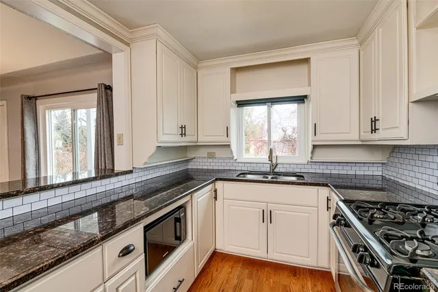 a kitchen with granite countertop white cabinets and white appliances