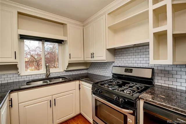 a kitchen with a stove a sink and a window